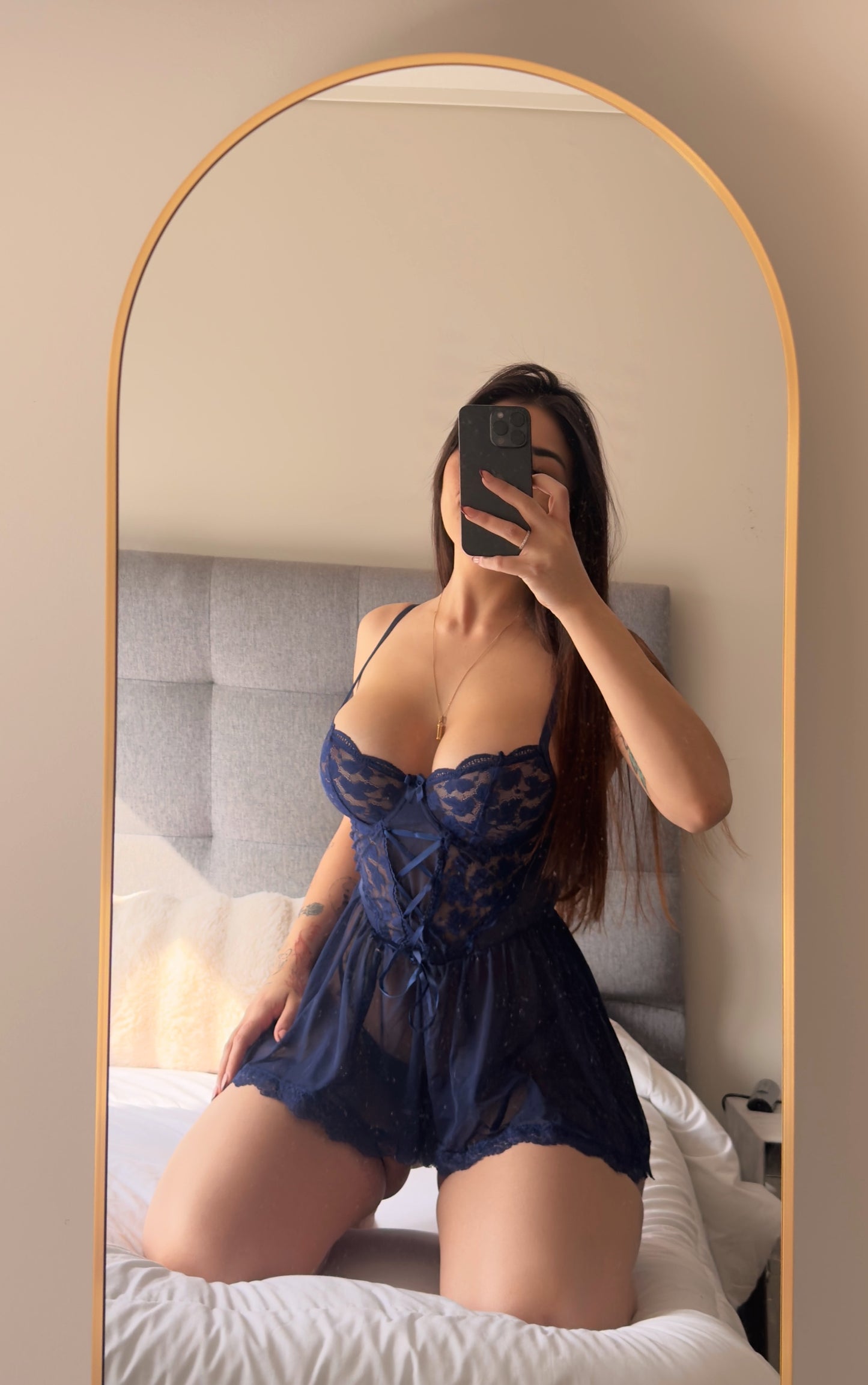 modelo sobre cama espejo celular usando Babydoll encaje cintas y porta ligas encanto azul cavrini 