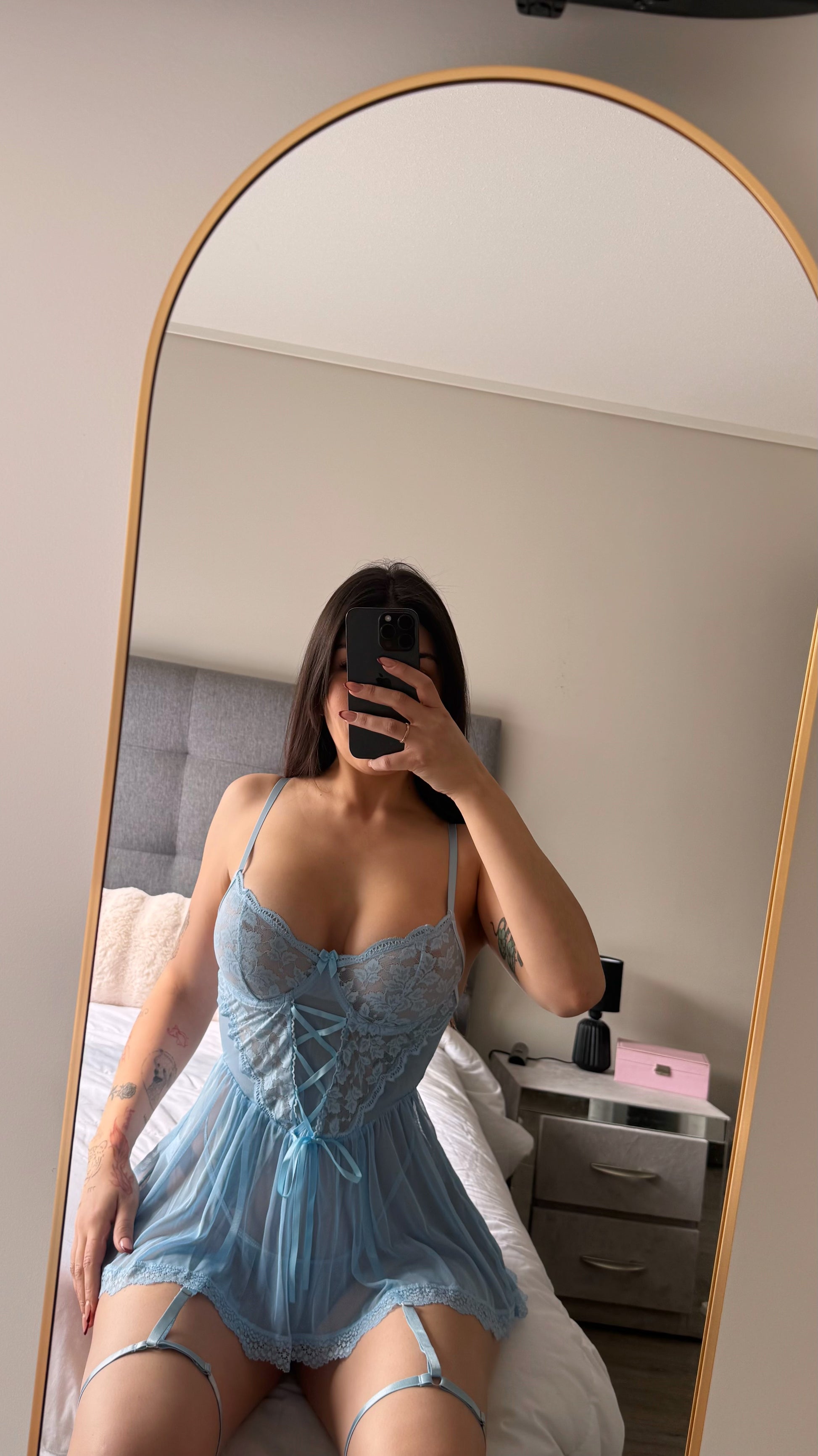 vista frontal de modelo sobre cama espejo y celular  usando babydoll celeste cavrini